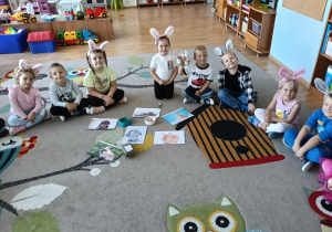Dzieci oglądają ilustracje z królikami.