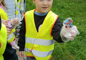 Chłopiec znalazł papierki na chodniku.