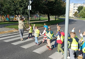 Dzieci przechodzą przez jezdnię po pasach