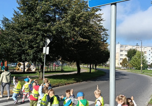Dzieci przechodzą przez jezdnię po pasach