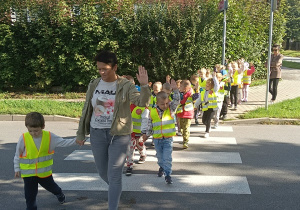 Dzieci przechodzą przez jezdnię po pasach