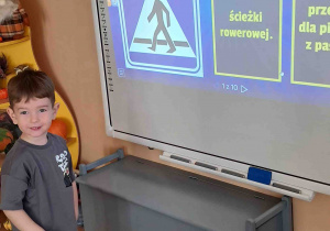 Chłopiec przy tablicy multimedialnej