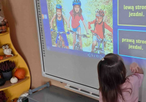 Dziewczynka przy tablicy multimedialnej