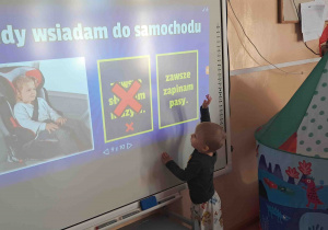Chłopiec przy tablicy multimedialnej
