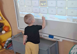 Chłopiec przy tablicy multimedialnej