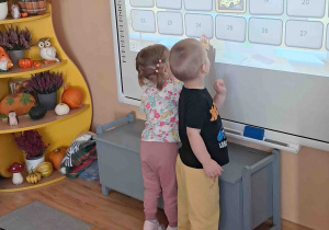 Chłopiec przy tablicy multimedialnej