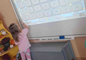 Dziewczynka przy tablicy multimedialnej