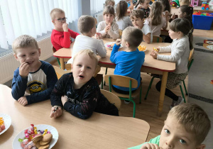 Dzieci jedzą przekąski przy stoliku