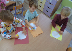 Dzieci wykonują pracę plastyczną ,,Uśmiechnij się".