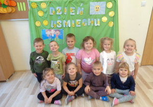 Dzieci pozują do zdjęcia na tle dekoracji.