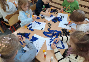 Dzieci wykonują pracę plastyczną - znaki drogowe techniką wyklejanki