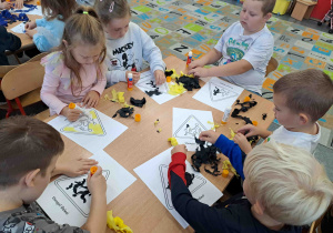 Dzieci wykonują pracę plastyczną - znaki drogowe techniką wyklejanki