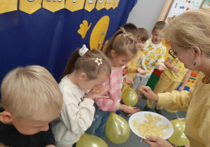 Dzieci degustują cytryny i próbują uśmiechnąć się po jej zjedzeniu.