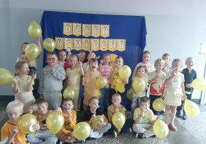 Wykonane zdjęcie grupy na tle napisu - dzień uśmiechu.