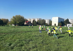 Dzieci szukają śmieci na terenie wokół przedszkola.