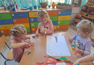 Dzieci wykonują prace w grupach przy stoliku