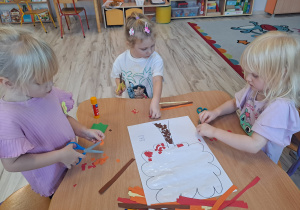 Dzieci wykonują prace w grupach przy stoliku