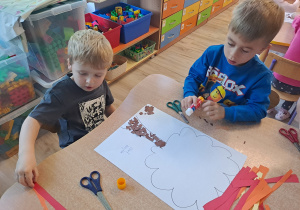 Dzieci wykonują prace w grupach przy stoliku