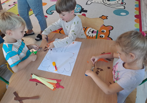 Dzieci wykonują prace w grupach przy stoliku