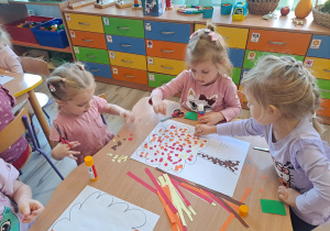 Dzieci wykonują prace w grupach przy stoliku