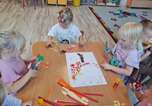 Dzieci wykonują prace w grupach przy stoliku