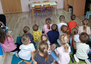 Dzieci słuchają piosenki o kundelku wyświetlanej na tablicy multimedialnej.