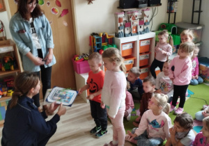 Dzieci wręczają Pani policjantce pamiątkowy dyplom oraz album z tematycznymi pracami plastycznymi.