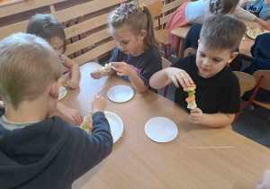 Dzieci wykonują szaszłyki z owoców