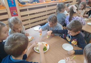 Dzieci wykonują szaszłyki z owoców