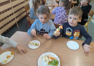 Dzieci wykonują szaszłyki z owoców