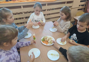 Dzieci wykonują szaszłyki z owoców