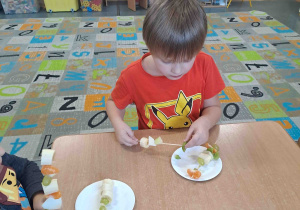 Dzieci wykonują szaszłyki z owoców