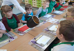 Pani dietetyk pokazuje dzieciom konsystencję ciasta na kopytka