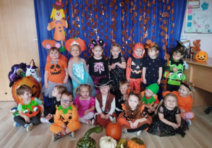 Dzieci pozują do zdjęcia na tle balowej dekoracji.