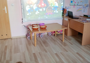 Dzieci oglądają zagadki dotyczące bajek wyświetlane na ekranie tablicy multimedialnej.