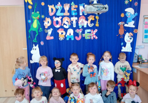 Dzieci pozują ze swoimi maskotkami na tle bajkowych dekoracji.