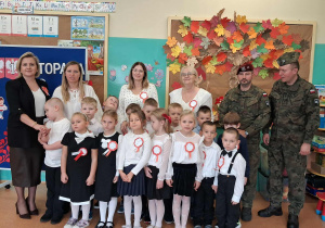 Pamiątkowe zdjęcie dzieci z panią wicedyrektor, nauczycielami i żołnierzami