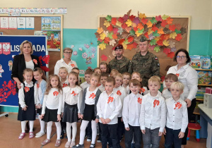 Pamiątkowe zdjęcie dzieci z panią wicedyrektor, nauczycielami i żołnierzami
