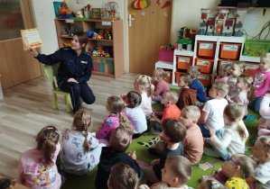 Pani Policjantka czyta i pokazuje dzieciom książkę