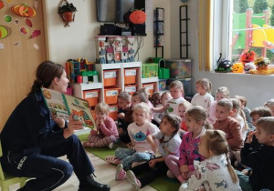 Pani Policjantka czyta i pokazuje dzieciom książkę