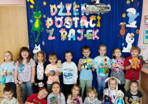 Dzieci pozują ze swoimi zabawkami na tle dekoracji