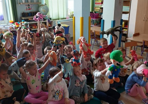 Dzieci unoszą swoje zabawki do góry