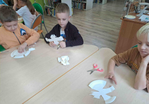 Dzieci wycinają z talerzyków kształt orła