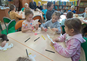 Dzieci wycinają z talerzyków kształt orła
