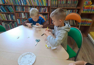 Dzieci wycinają z talerzyków kształt orła