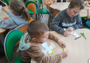 Dzieci dorysowują elementy na wizerunku orła - dziób i koronę