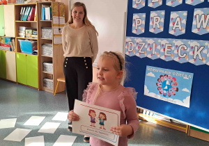 Dziewczynka wypowiada się na temat ilustracji trzymanej w rączkach