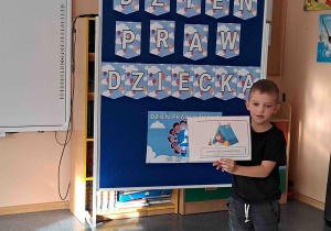 Chłopiec wypowiada się na temat ilustracji trzymanej w rączkach