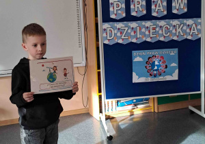 Chłopiec wypowiada się na temat ilustracji trzymanej w rączkach