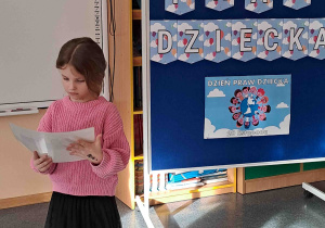 Dziewczynka wypowiada się na temat ilustracji trzymanej w rączkach